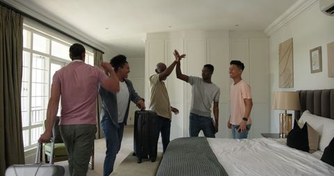 Friends packing suitcases in bedroom preparing for journey