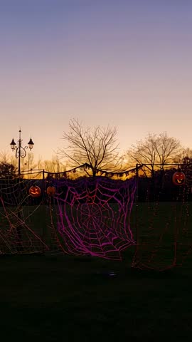 Capturing Halloween dusk with glowing jack-o'-lanterns on purple spider-web netting