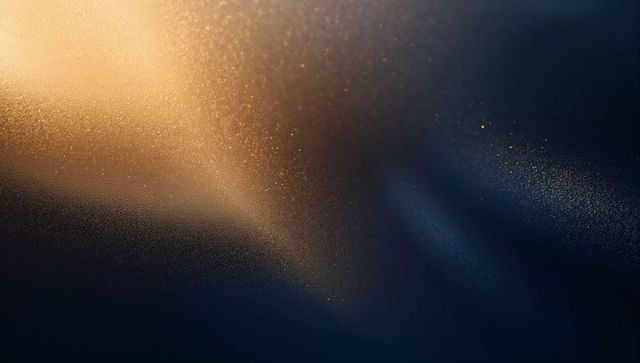 Golden light gradient illuminating dark textured surface with metallic specks