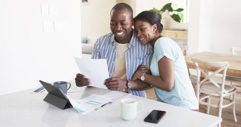 Happy couple reviewing finances at home