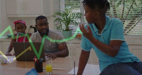 Working father guiding children with laptop and financial chart overlay at kitchen table