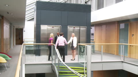 Business Professionals Shaking Hands in Modern Office Atrium