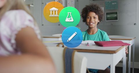 Smiling biracial schoolboy in classroom with educational icons