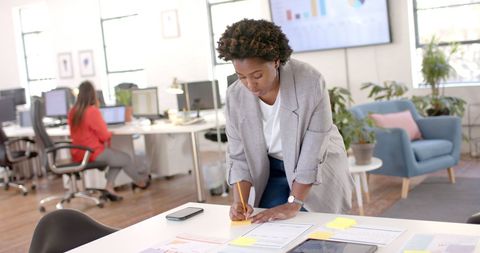 Focused Businesswoman Taking Notes in Modern Office Interior