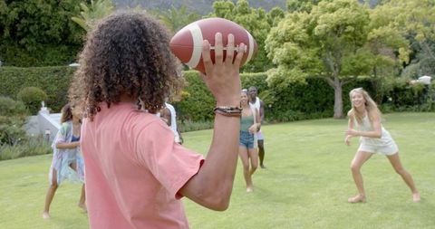 Group of Friends Playing Football in Lush Backyard