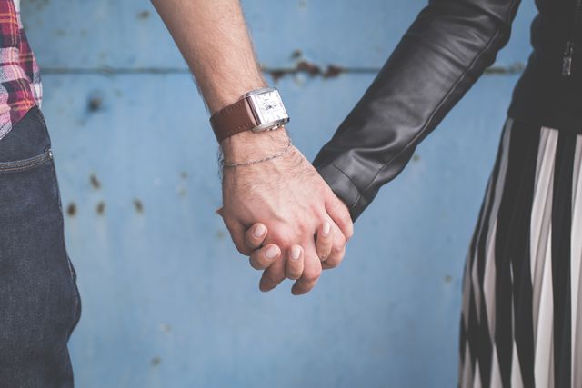 Close-up of a couple holding hands, symbolizing support, love, and connection. Perfect for use in materials related to romance, relationships, emotional bonds, dating apps, or human connection.