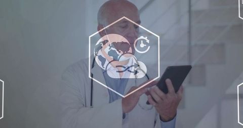Senior doctor using tablet with telemedicine digital overlay in modern clinic