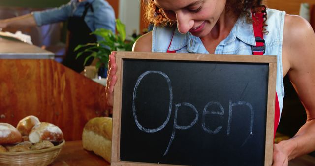 Smiling Woman Holding Open Sign in Bakery - Download Free Stock Images Pikwizard.com