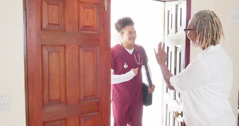 Healthcare Worker Greeting Senior Woman at Door for Home Visit