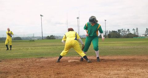 Women Competing in Intense Softball Match on Field