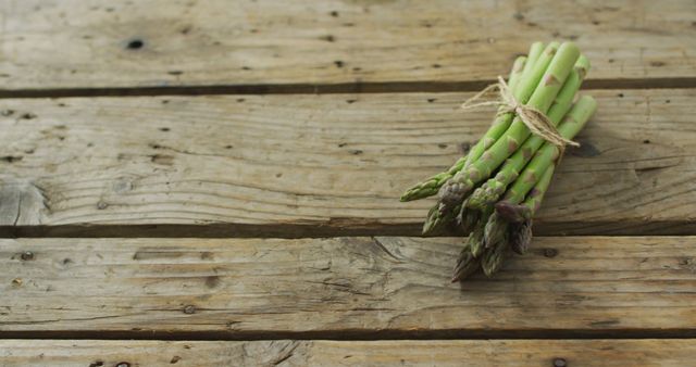 Image of fresh asparagus bundle on wooden background. fusion food, fresh vegetables and healthy eating concept.