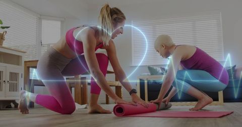 Lesbian couple exercising with heart monitor indoors