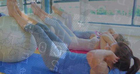 Women exercising on stability balls in fitness studio