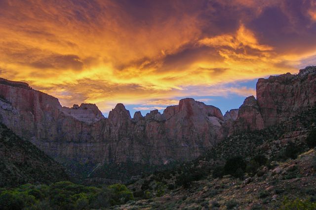 This image depicts a stunning sunset casting vibrant colors over a rugged mountain range. Ideal for travel and nature blogs, promoting outdoor adventures, and illustrating articles on natural beauty and wilderness exploration.