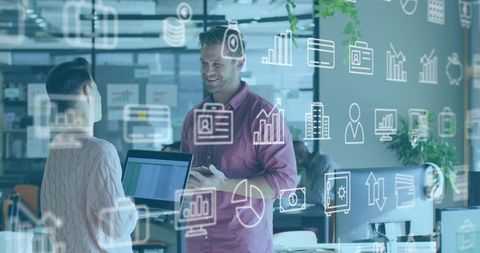 Smiling colleagues discussing data analytics with digital overlays in modern office