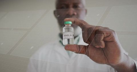 Medical researcher holding covid-19 vaccine vial with futuristic digital interface