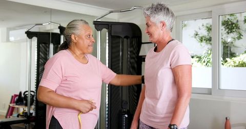 Senior Lesbian Couple Exercising Together at Home Gym