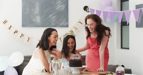 Women Celebrating Birthday at Festive Gathering with Cake