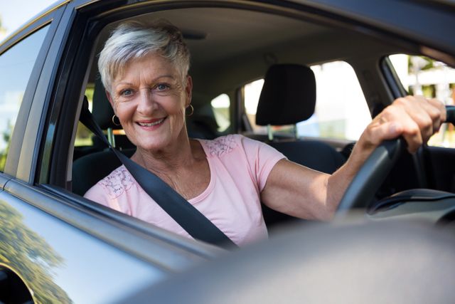 Portrait of happy senior woman driving a car