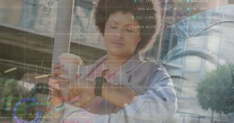 Professional woman checking smartwatch while holding coffee with ar data overlay in downtown plaza