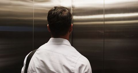 Businessman awaiting arrival in office elevator