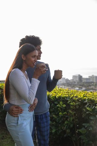 Couple Relaxing with Coffee Overlooking City Skyline