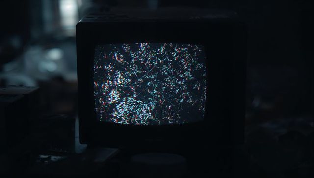 Retro CRT Monitor Displaying Static Glitches in Dark Workshop