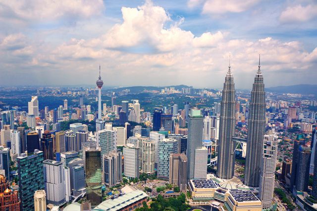Aerial photo showing Kuala Lumpur's skyline with iconic Petronas Towers. Perfect for use in travel guides, tourism promotions, architectural magazines, and business-related articles highlighting the city's economic and architectural significance.
