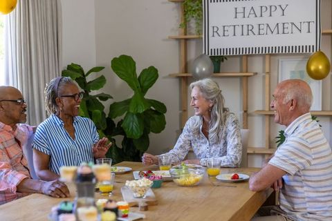 Senior friends celebrating retirement at home with joyful gathering