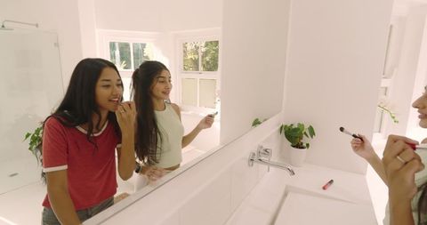 Diverse Friends Applying Makeup in Bright Modern Bathroom
