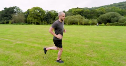 Man Jogging in Green Field Embracing Outdoor Fitness - Download Free Stock Images Pikwizard.com