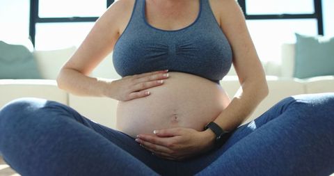 Pregnant Woman Practicing Mindfulness at Home with Fitness Tracker