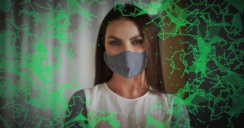Woman wearing gray face mask with futuristic green network overlay for health tech concept