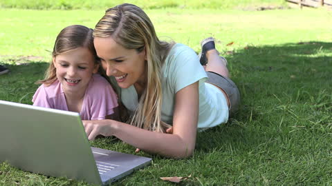 Mother and Daughter Enjoy Outdoor Learning with Laptop