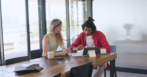 Young Professionals Collaborating on Project with Tablet and Coffee