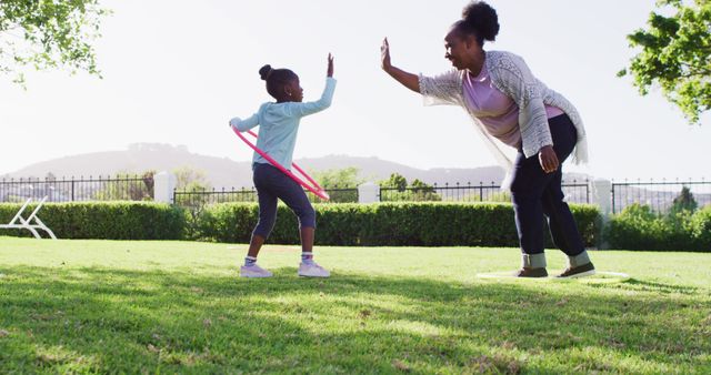 Grandmother and Granddaughter Enjoying Outdoor Playtime with Hula Hoop - Download Free Stock Images Pikwizard.com