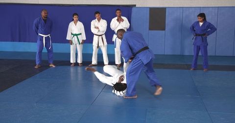 Judo instructor demonstrating technique to students in dojo