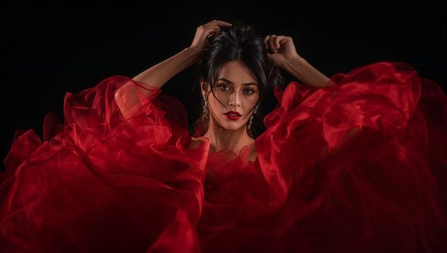 Stunning woman in flowing red chiffon gown with elegant posing
