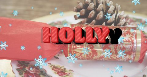 Festive holly text on christmas gift with pine cone and snowflakes