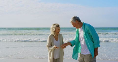 Smiling Senior Couple Enjoying Leisurely Walk by the Beach