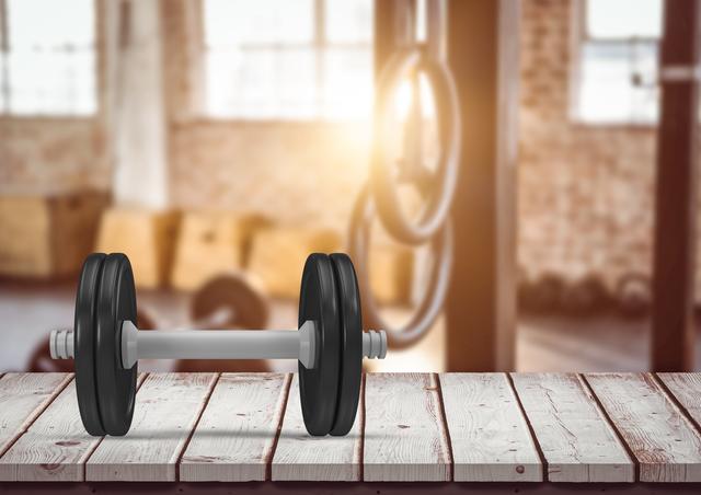 Close-up of dumbbell on a wooden plank in the gym