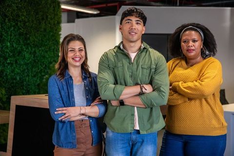 Standing confident diverse team in modern open-plan office for business branding