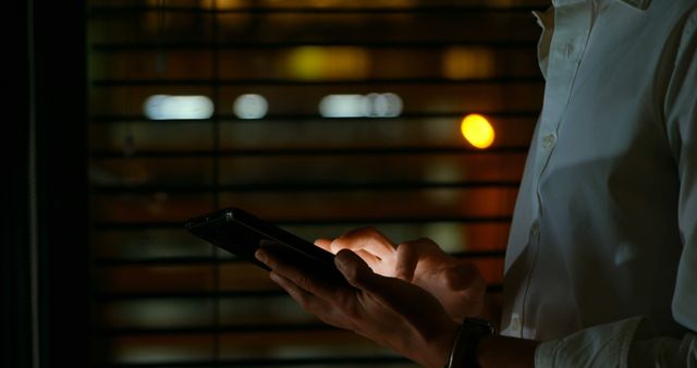 Man Typing on Smartphone in Dimly Lit Environment - Download Free Stock Images Pikwizard.com