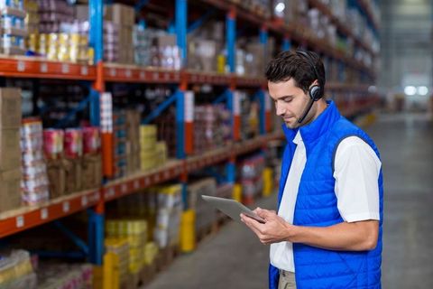 Warehouse worker using tablet for inventory management in distribution center