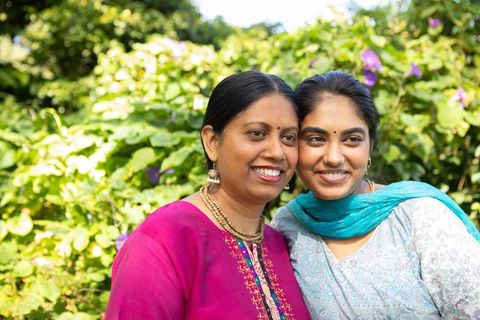 Indian Mother and Daughter Smiling in Sunlit Garden