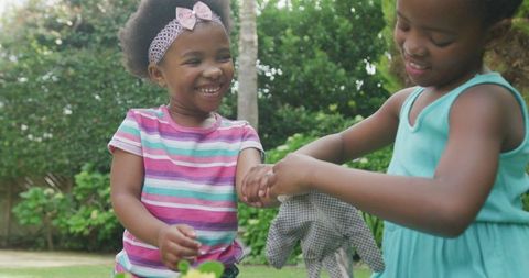 Joyful African American Girls Gardening Outdoors Together