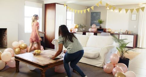 Friends Decorating Living Room for Birthday Party Celebration