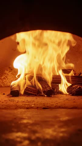 Vertical video glowing embers igniting flames in rustic stone oven
