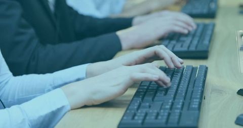 Business professionals typing on keyboards in modern office environment