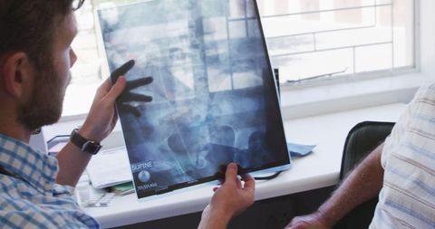 Doctor Examining X-Ray with Senior Patient in Medical Consultation